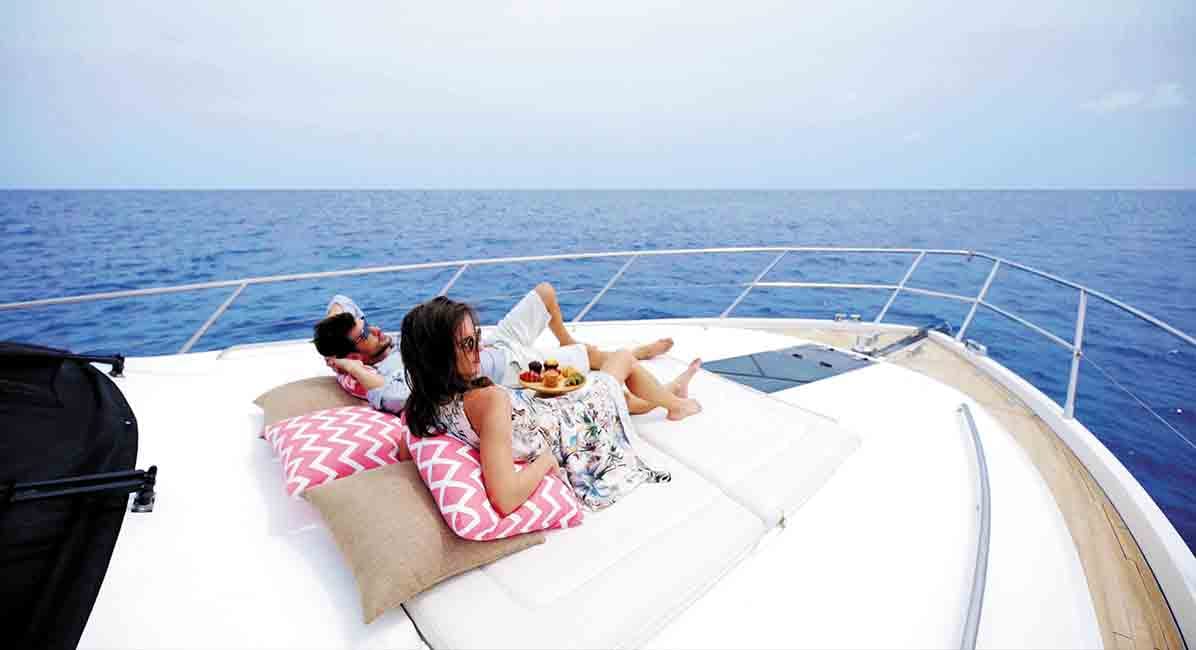 A couple lounging on a luxury yacht, on a cruise excursion from The Nautilus Maldives