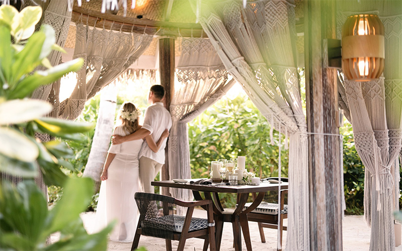 A bride and groom at Ocaso, the beachside grill restaurant at The Nautilus Maldives