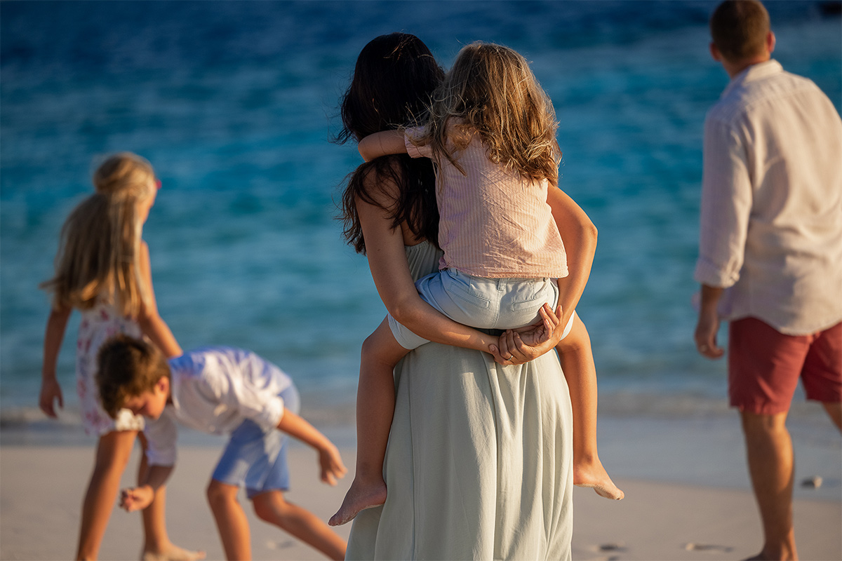 A family walking on the beach at The Nautilus Maldives