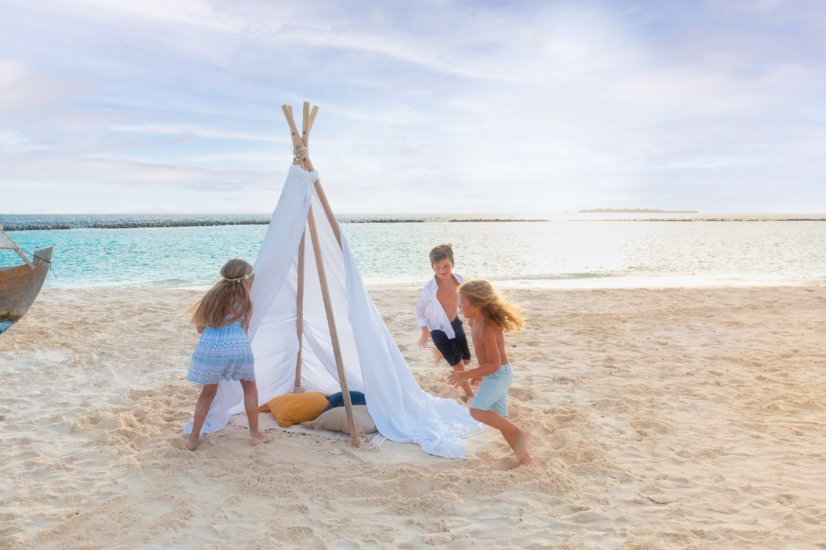 Three young children playing on the sand at The Nautilus Maldives