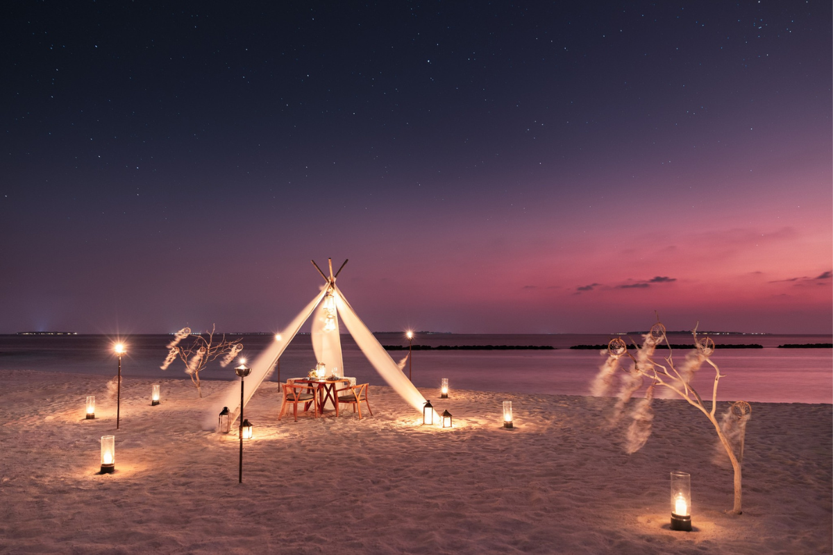 Private dining setup on the beach at The Nautilus Maldives
