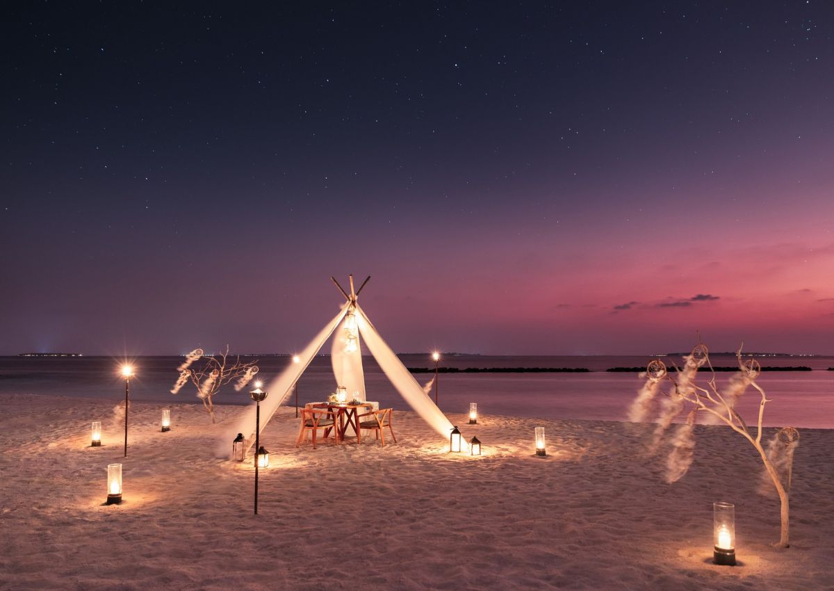 Private dining setup on the beach at The Nautilus Maldives