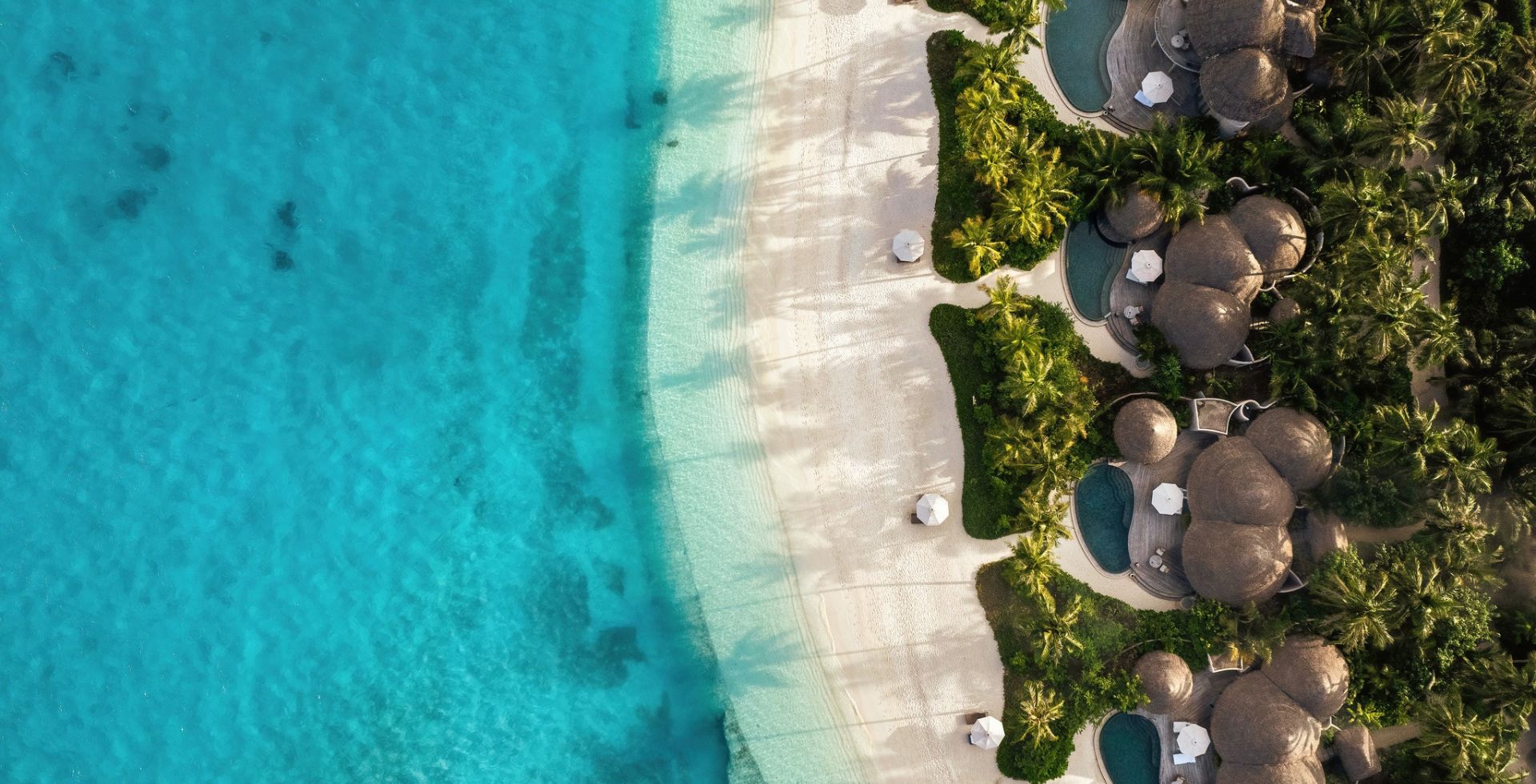 The Nautilus Maldives aerial view — private beach houses with infinity pools along white sand, Baa Atoll