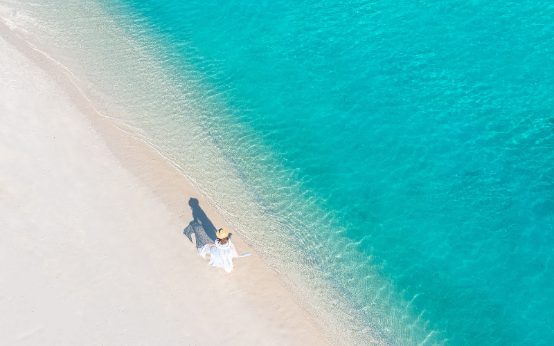 A woman walking on the powdery white beach at The Nautilus Maldives