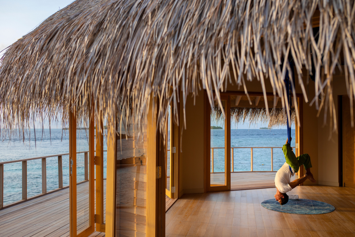 A person doing aerial yoga at the yoga pavillion during sunrise