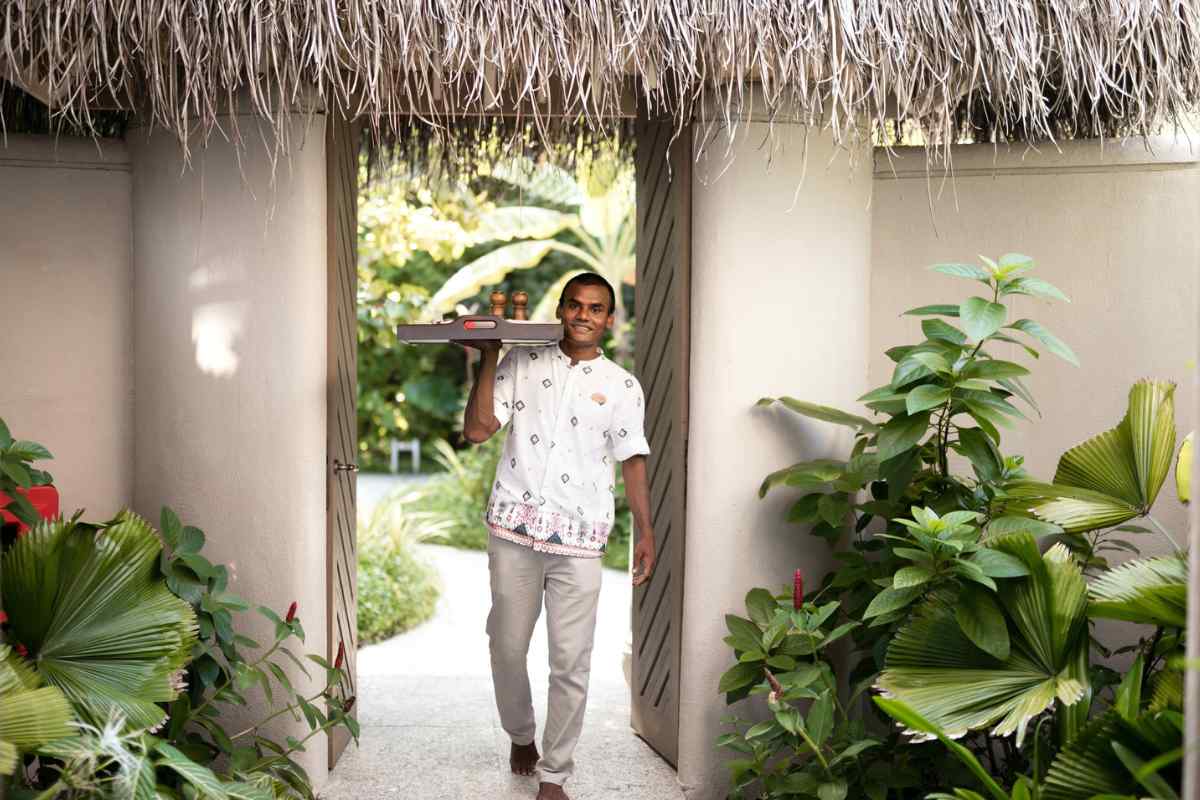 A housemaster, or personal butler, walking with a tray to provide room service