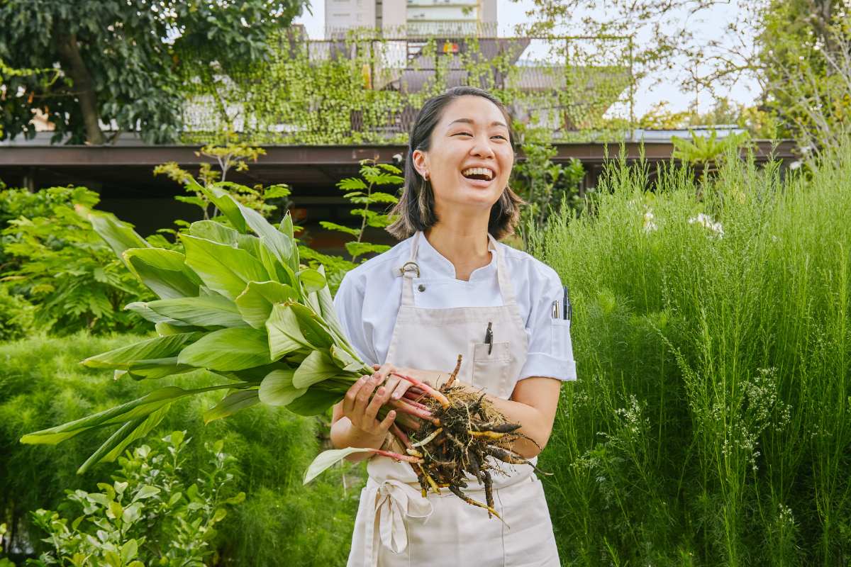 Visiting chef Tam from Thailand holding vegetable roots