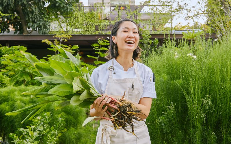 Visiting chef Tam from Thailand holding vegetable roots