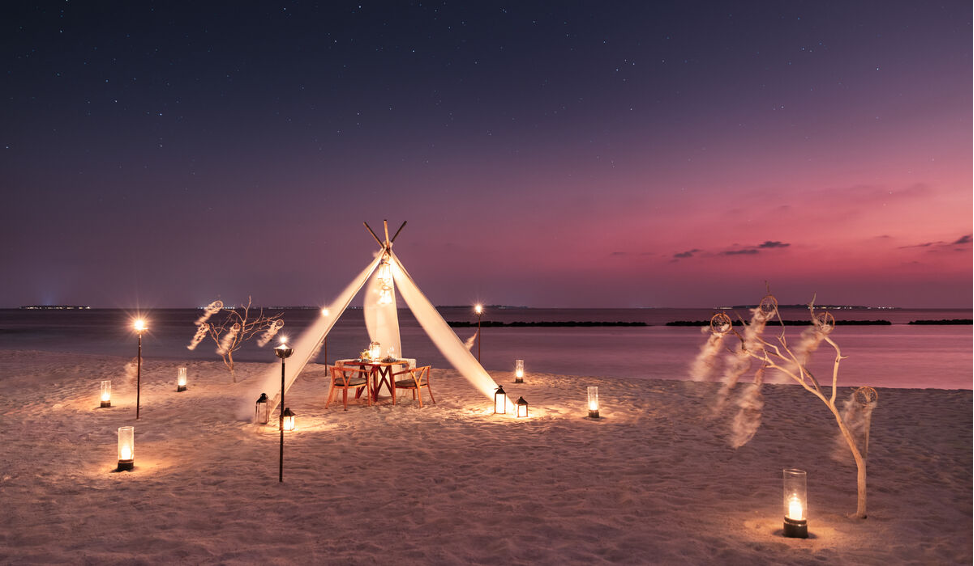 Private dining setup on the beach at The Nautilus Maldives