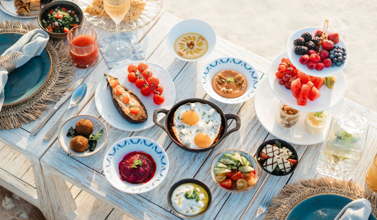 The Nautilus Extravagant Breakfast experience, with an array of Mediterranean dishes laid out on a table on the beach