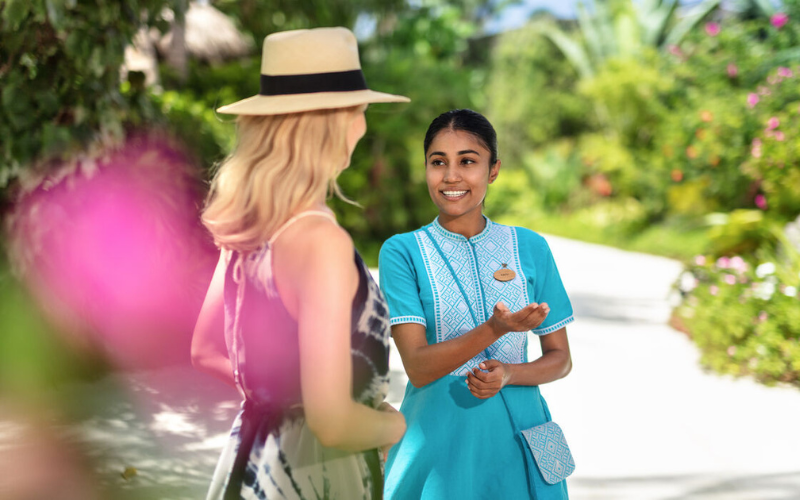 A personal butler at The Nautilus Maldives showing directions to a guest