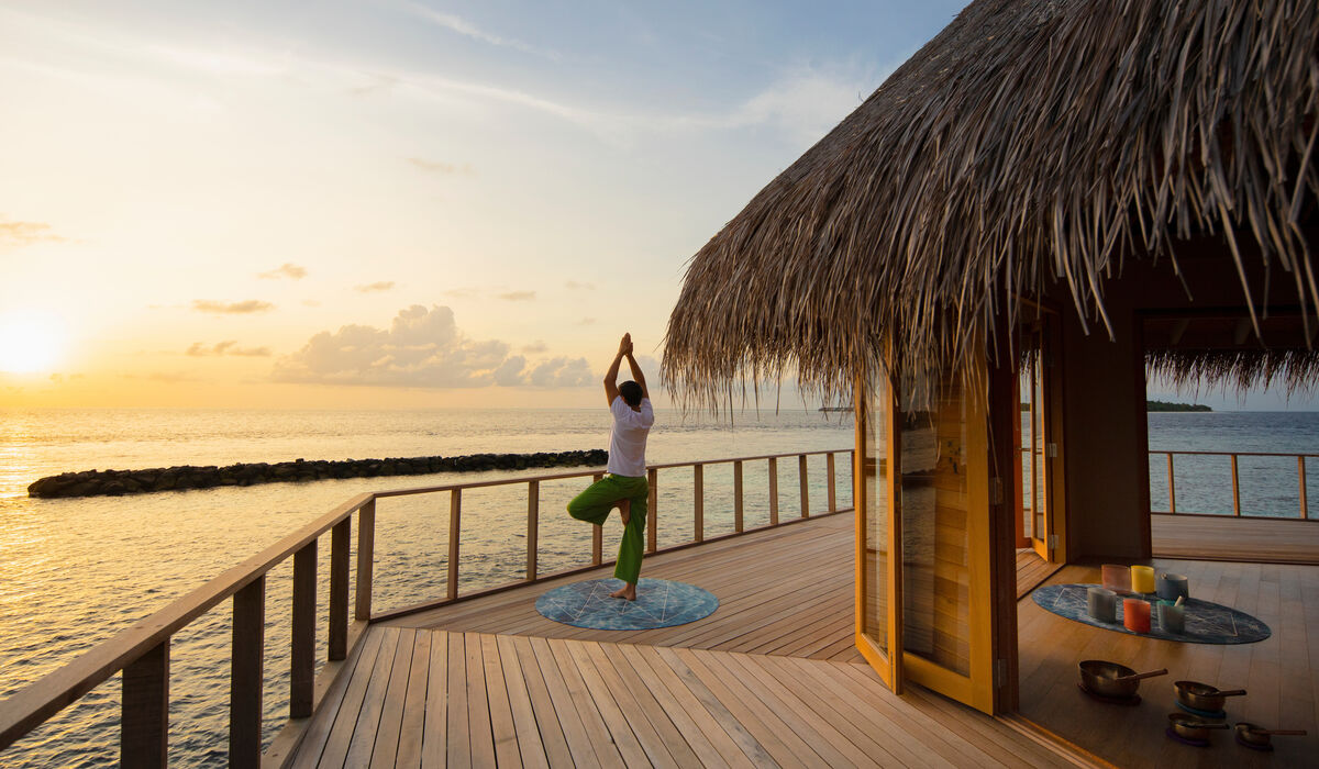 A man doing yoga at the Yoga Pavilion at The Nautilus Maldives