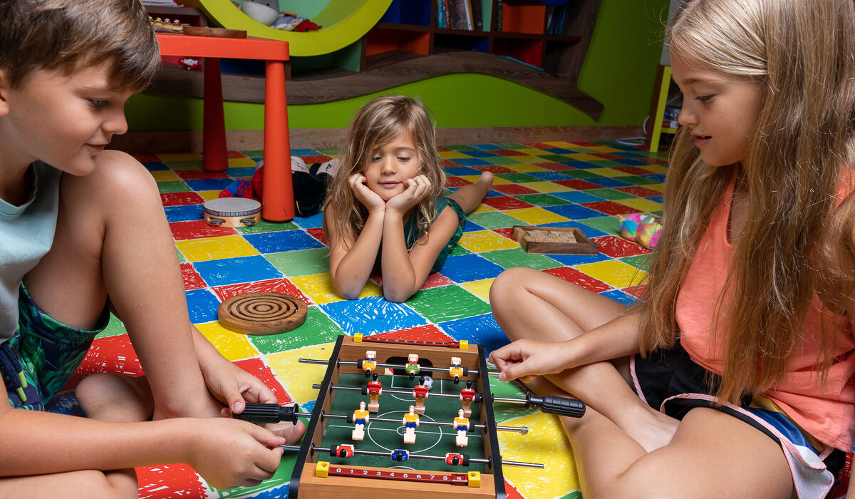 Kids playing foosball at Young Wonderers children's club
