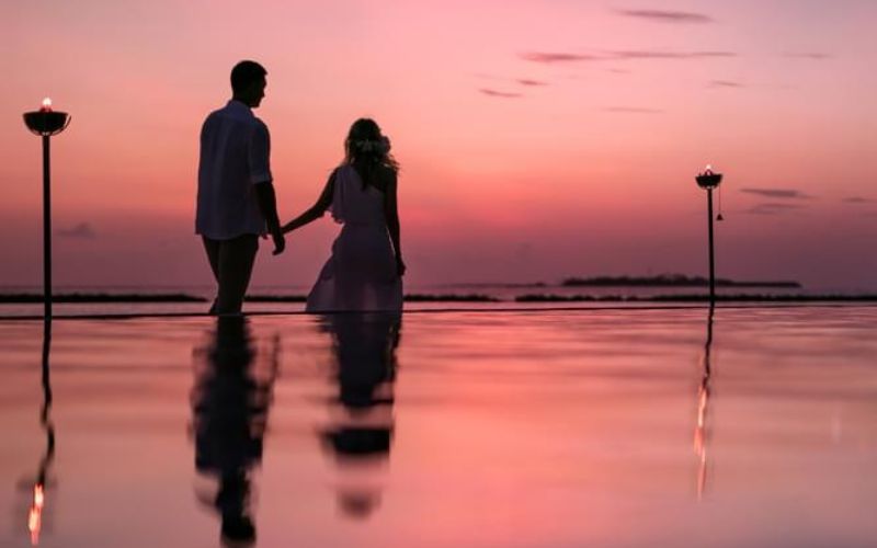 Couple holding hands at sunset