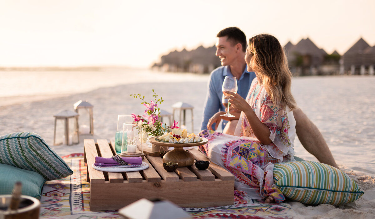 Couple having drinks and canapes on the beach at The Nautilus Maldives